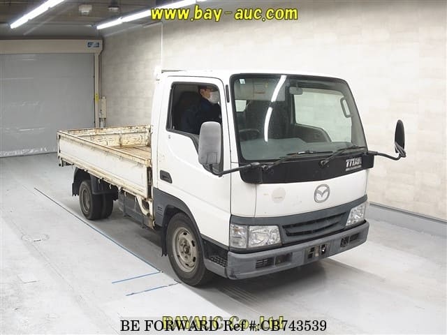 A grey JDM sports car speeding down a highway at night.