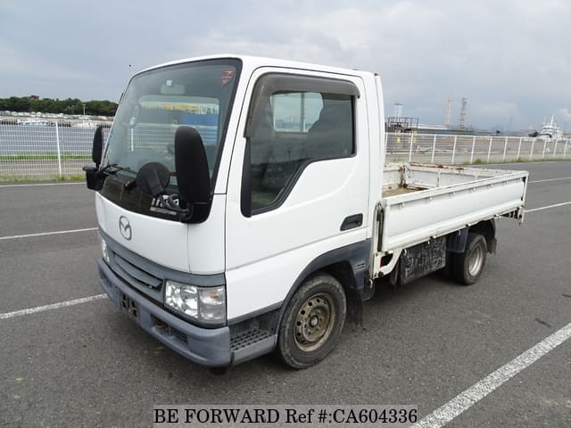 A grey JDM sports car speeding down a highway at night.