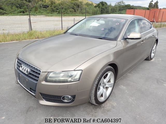 A grey JDM sports car speeding down a highway at night.
