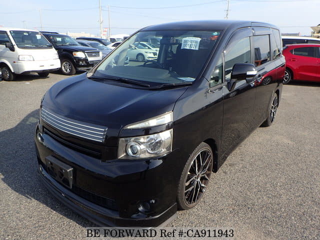 A grey JDM sports car speeding down a highway at night.