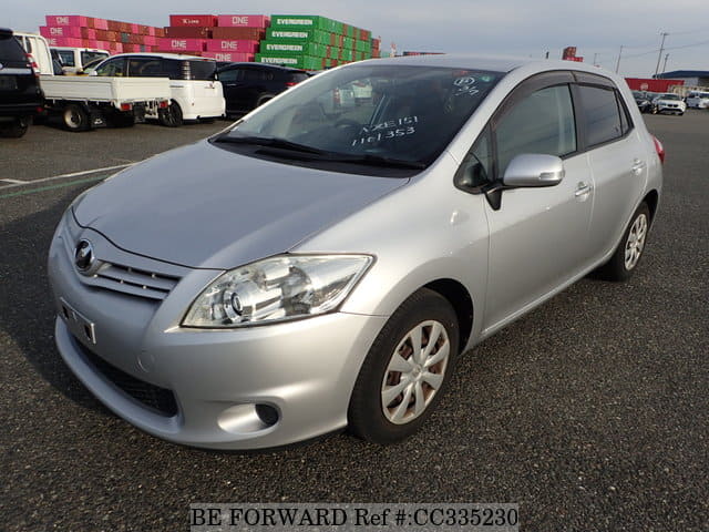 A grey sports car speeding down a highway at night.