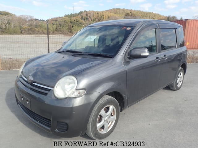 A grey JDM sports car speeding down a highway at night.