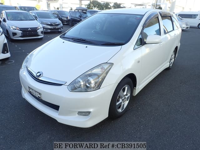 A grey JDM sports car speeding down a highway at night.