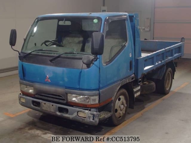 A grey sports car speeding down a highway at night.