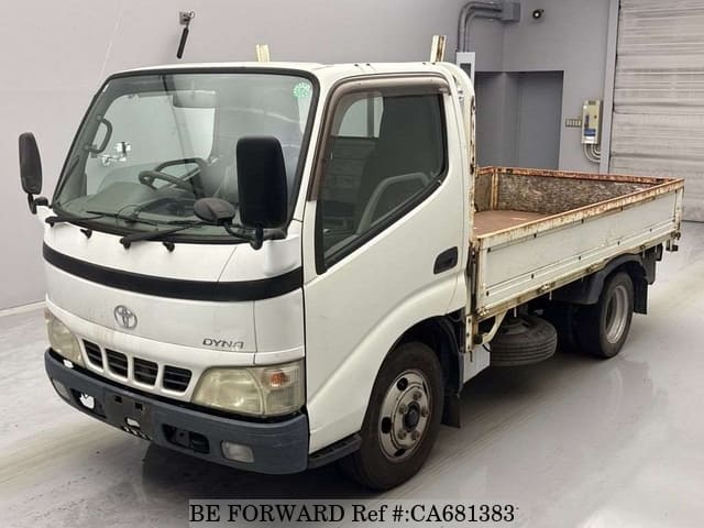A grey JDM sports car speeding down a highway at night.