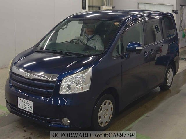 A grey JDM sports car speeding down a highway at night.