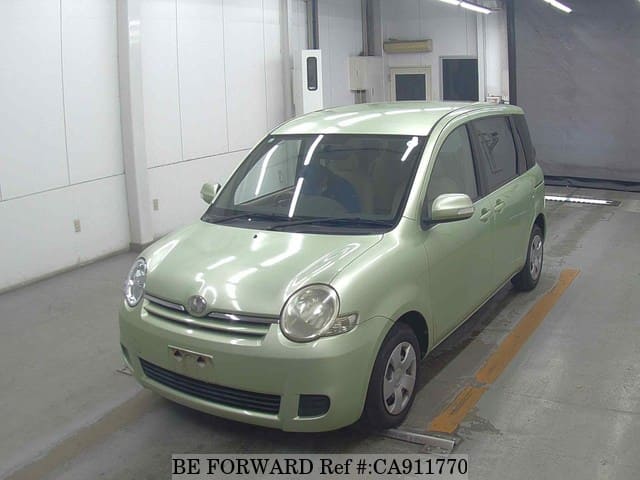 A grey sports car speeding down a highway at night.