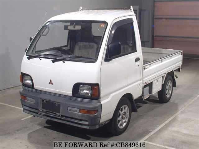 A grey JDM sports car speeding down a highway at night.