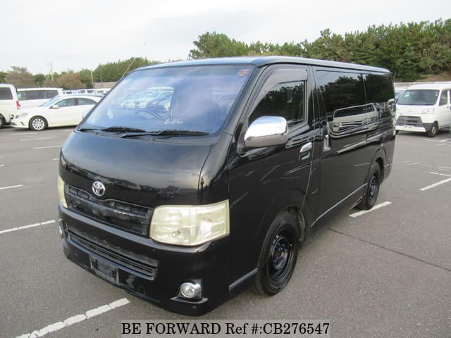 A grey JDM sports car speeding down a highway at night.