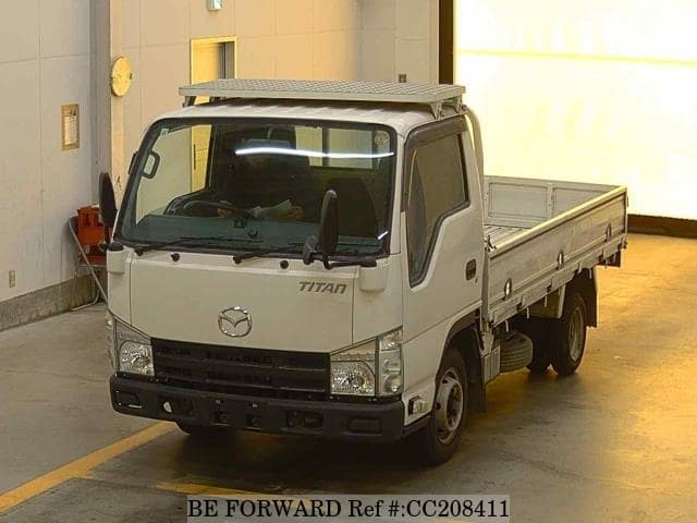 A grey sports car speeding down a highway at night.