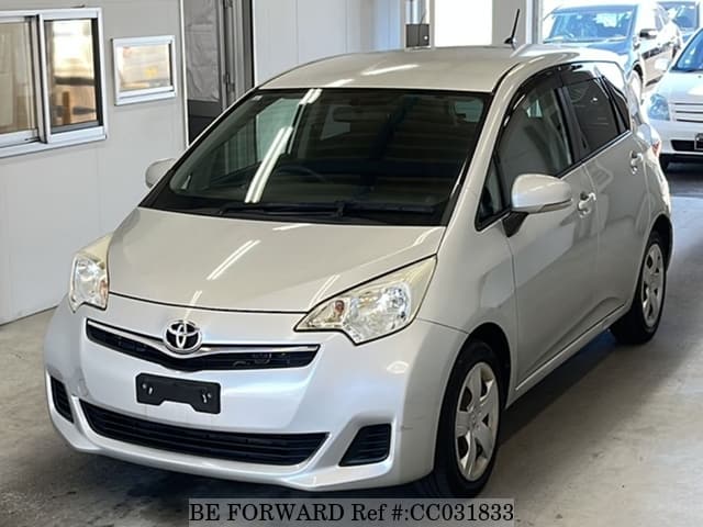 A grey sports car speeding down a highway at night.