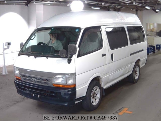 A grey JDM sports car speeding down a highway at night.