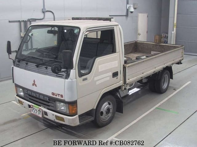 A grey sports car speeding down a highway at night.