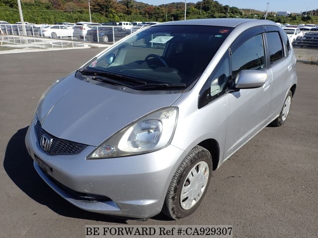 A grey JDM sports car speeding down a highway at night.