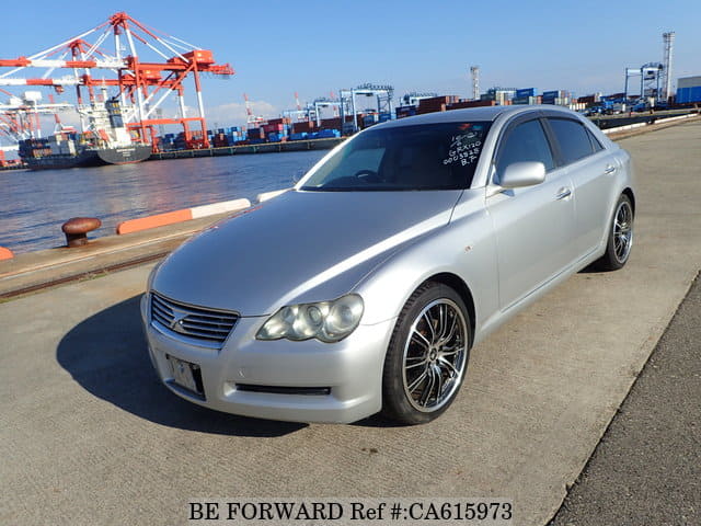 A grey JDM sports car speeding down a highway at night.