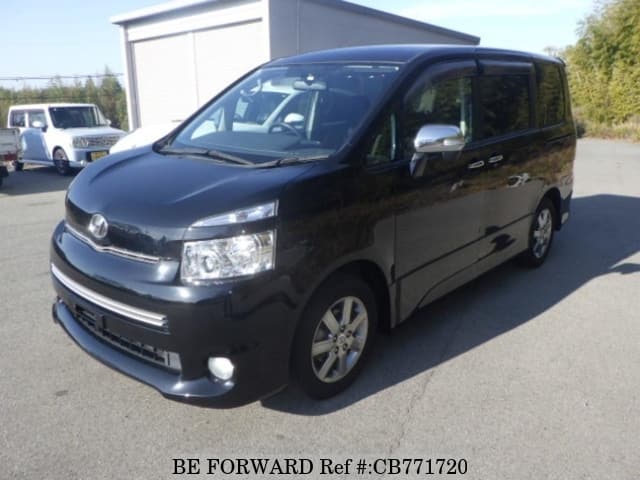 A grey JDM sports car speeding down a highway at night.