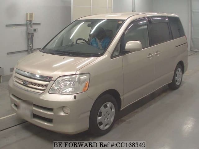 A grey sports car speeding down a highway at night.