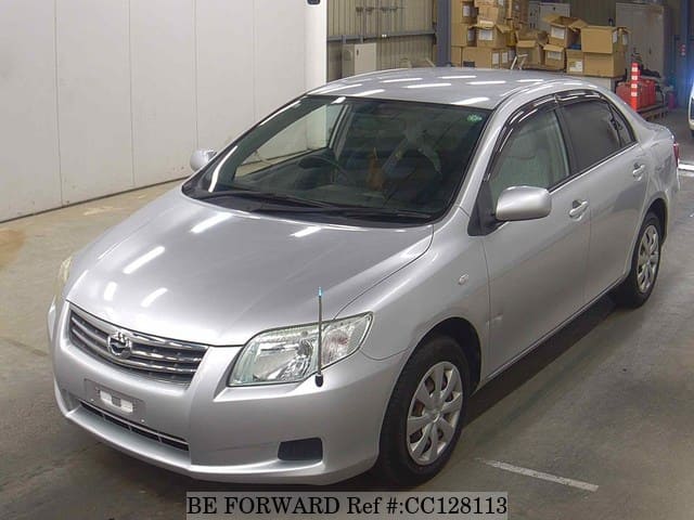 A grey sports car speeding down a highway at night.