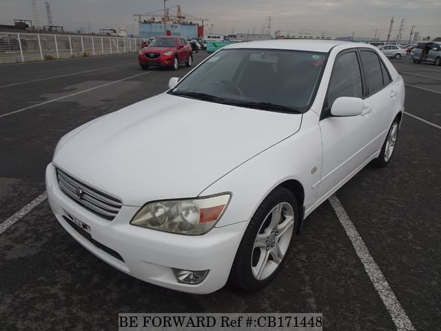 A grey JDM sports car speeding down a highway at night.