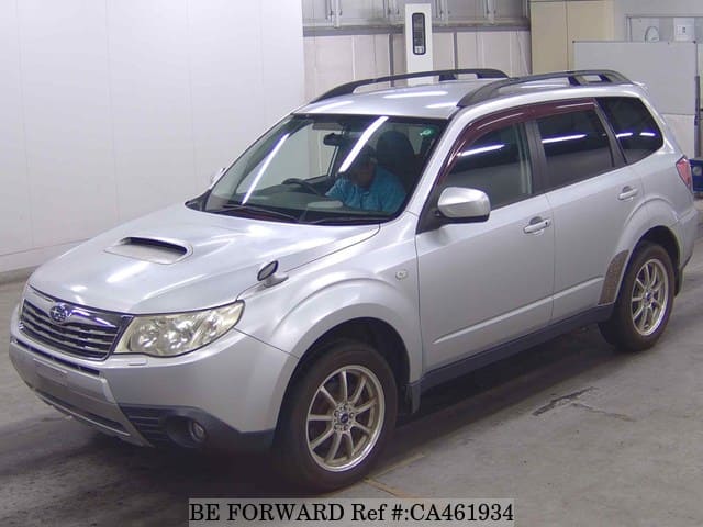 A grey JDM sports car speeding down a highway at night.