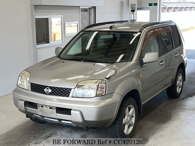 A grey JDM sports car speeding down a highway at night.