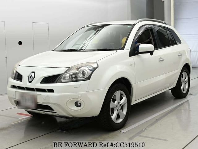 A grey sports car speeding down a highway at night.