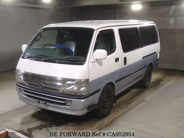 A grey sports car speeding down a highway at night.