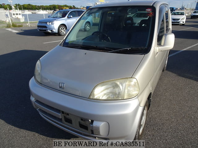 A grey JDM sports car speeding down a highway at night.