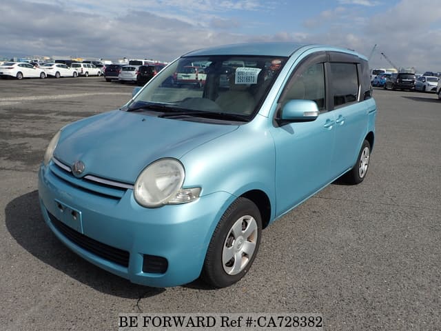 A grey JDM sports car speeding down a highway at night.