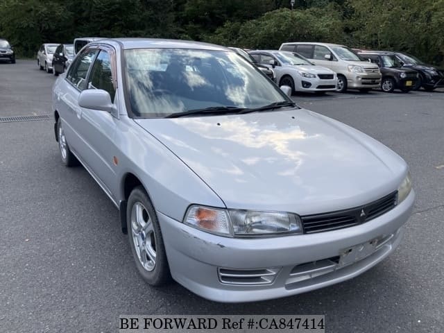 A grey JDM sports car speeding down a highway at night.