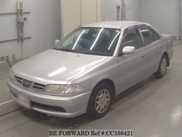 A grey sports car speeding down a highway at night.