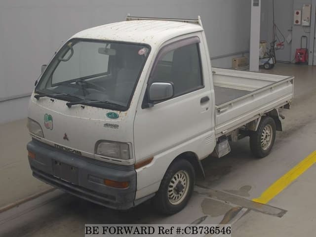 A grey JDM sports car speeding down a highway at night.