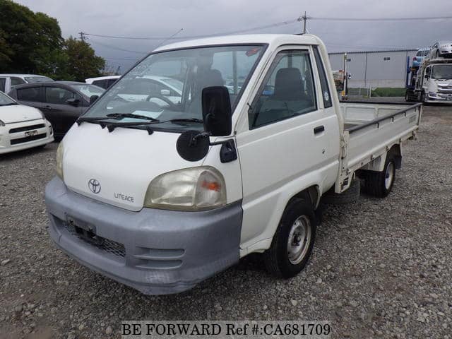 A grey JDM sports car speeding down a highway at night.