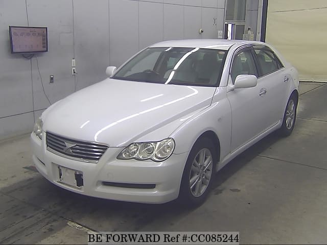 A grey sports car speeding down a highway at night.