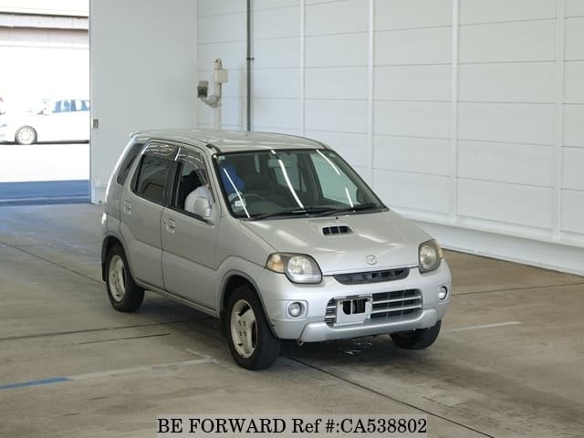 A grey JDM sports car speeding down a highway at night.