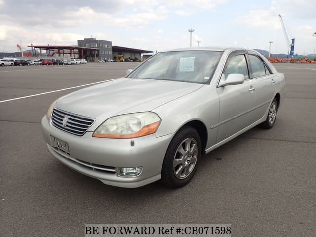 A grey JDM sports car speeding down a highway at night.