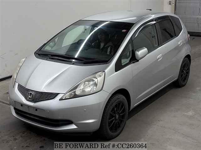 A grey sports car speeding down a highway at night.