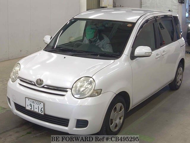 A grey JDM sports car speeding down a highway at night.