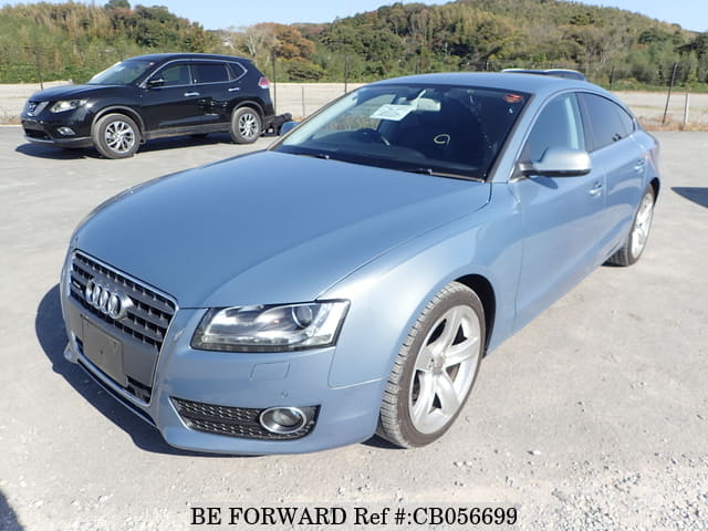 A grey JDM sports car speeding down a highway at night.
