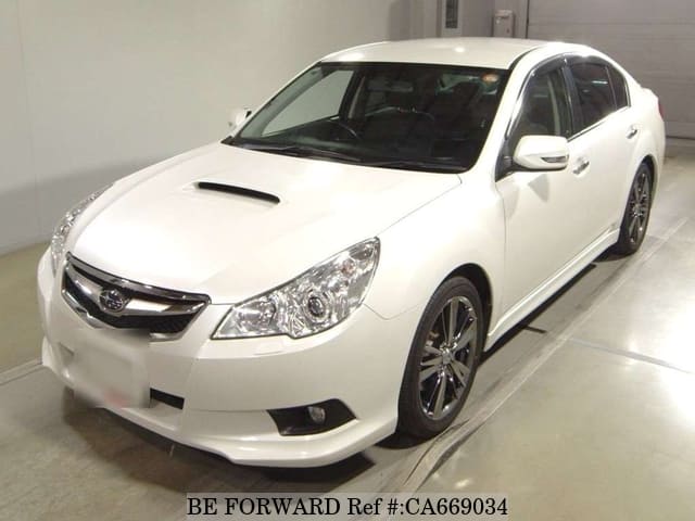 A grey JDM sports car speeding down a highway at night.