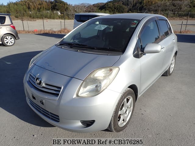 A grey sports car speeding down a highway at night.
