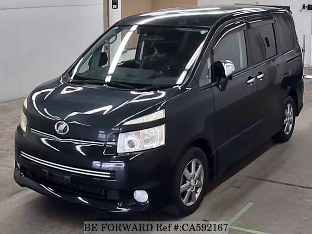 A grey JDM sports car speeding down a highway at night.