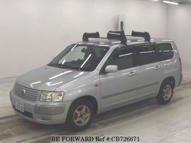 A grey JDM sports car speeding down a highway at night.