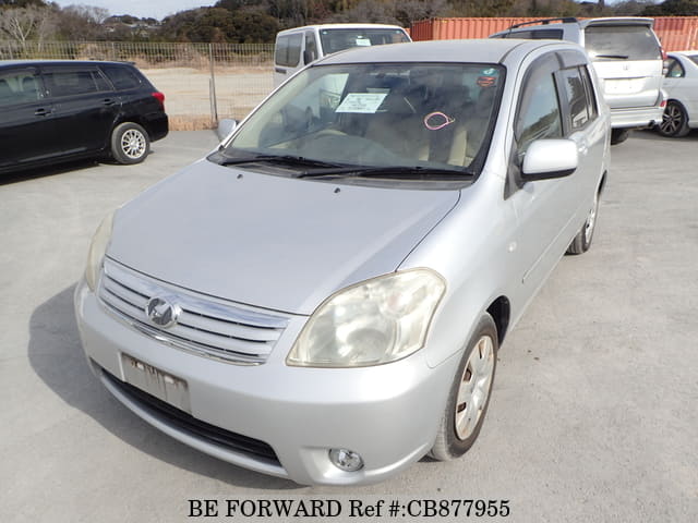 A grey JDM sports car speeding down a highway at night.