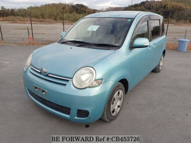 A grey JDM sports car speeding down a highway at night.