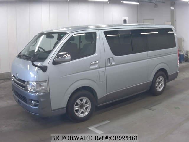 A grey sports car speeding down a highway at night.