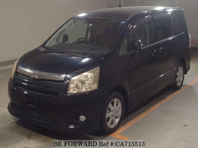 A grey JDM sports car speeding down a highway at night.