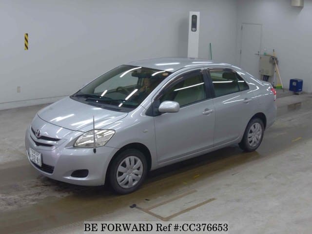 A grey sports car speeding down a highway at night.