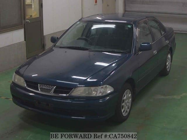 A grey JDM sports car speeding down a highway at night.