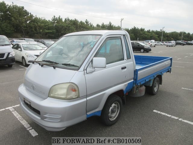 A grey JDM sports car speeding down a highway at night.